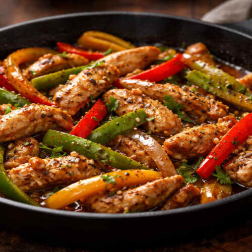 Chicken Pepper Stir Fry in a pan with bell peppers and black pepper